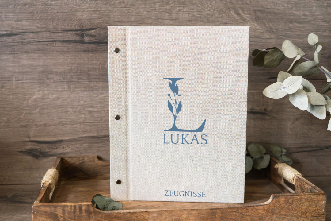 Zeugnismappe Leinen personalisiert mit Namen Anna und Monogramm, auf Holztablett mit Eukalyptuszweig, in der Farbe Jeans